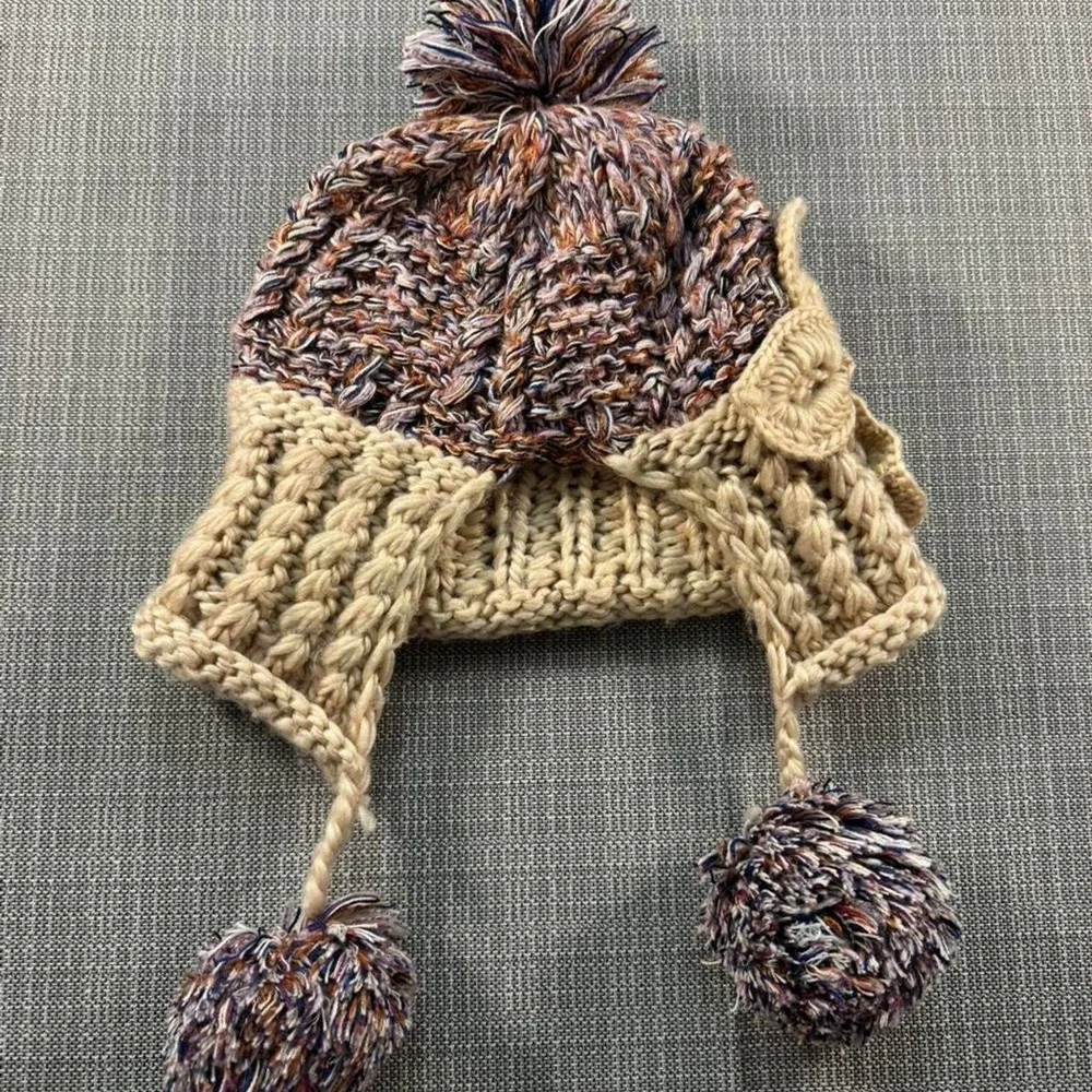 Multicolored knitted hat with pom poms